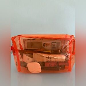 Makeup orange clear bag with a variety of beauty products, bag new without tags